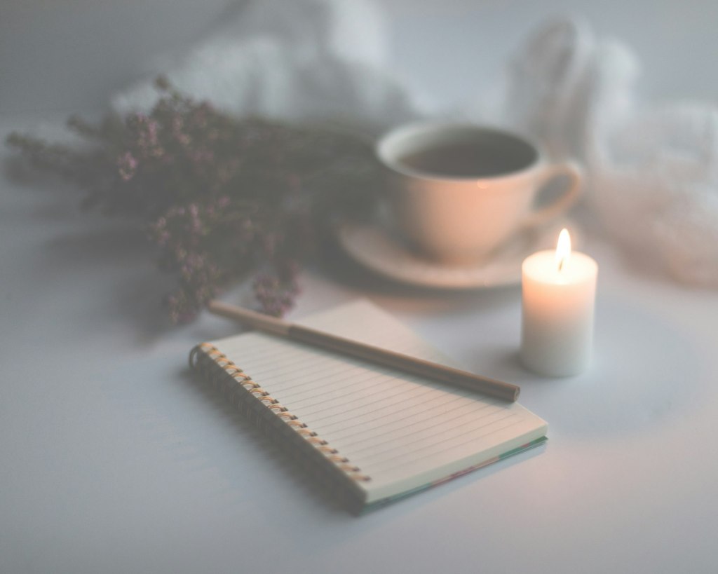 Mercury retrograde in Scorpio 2026: a white candle on ruled paper beside a mug