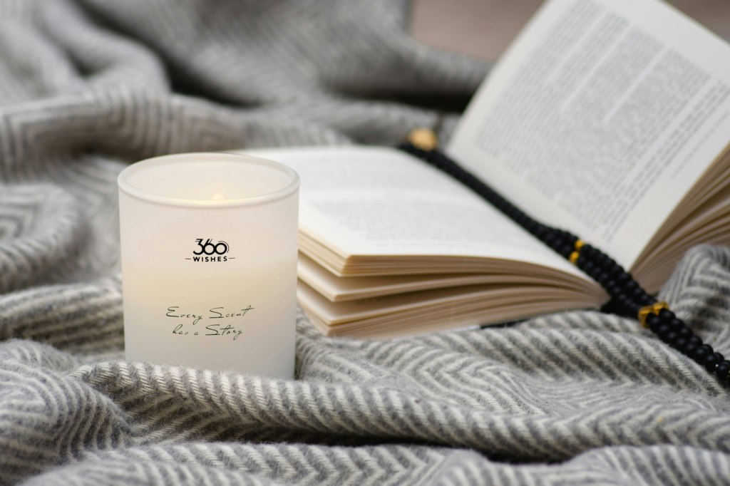 Practical Magic 2 and witch films: a lit candle and a book resting on a blanket