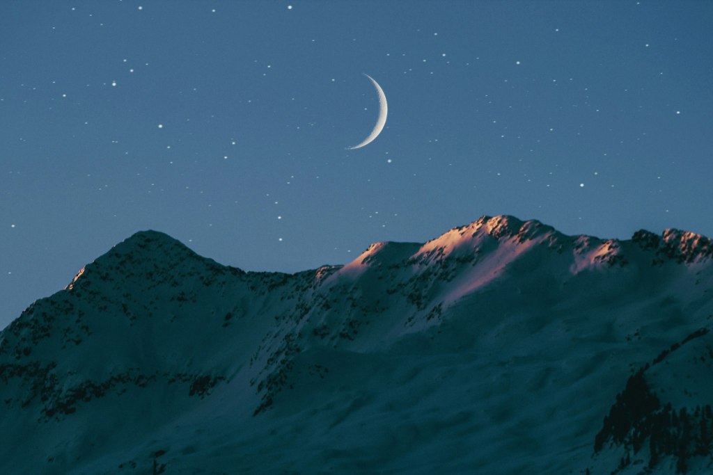 Scorpio new moon November 2026: a thin crescent moon above a mountain ridge